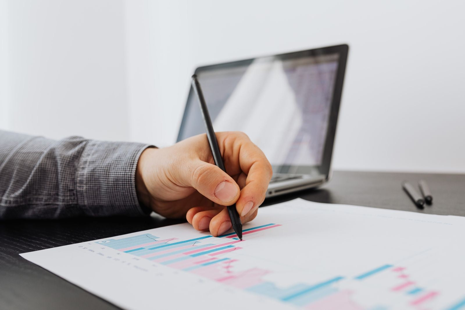 A professional reviewing a business growth chart with a laptop, representing CAPM salary and career progression.