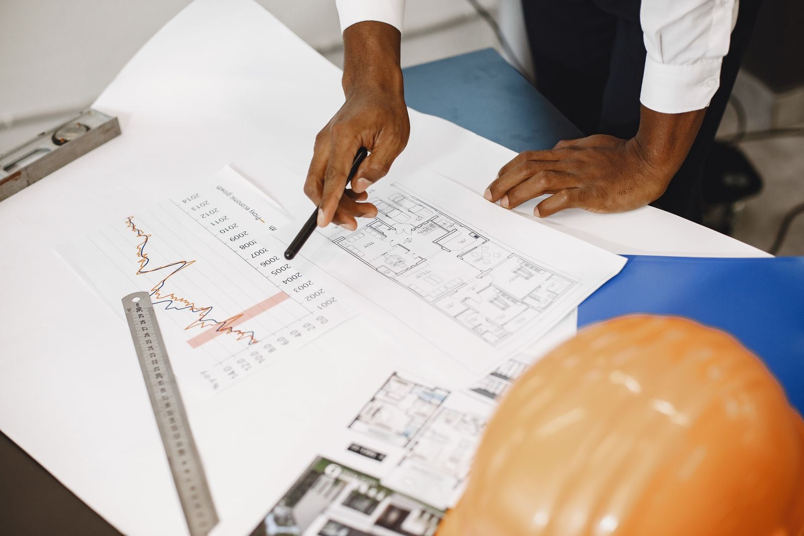A professional analyzing plans and cost figures to estimate a project, representing cost estimation in project management.