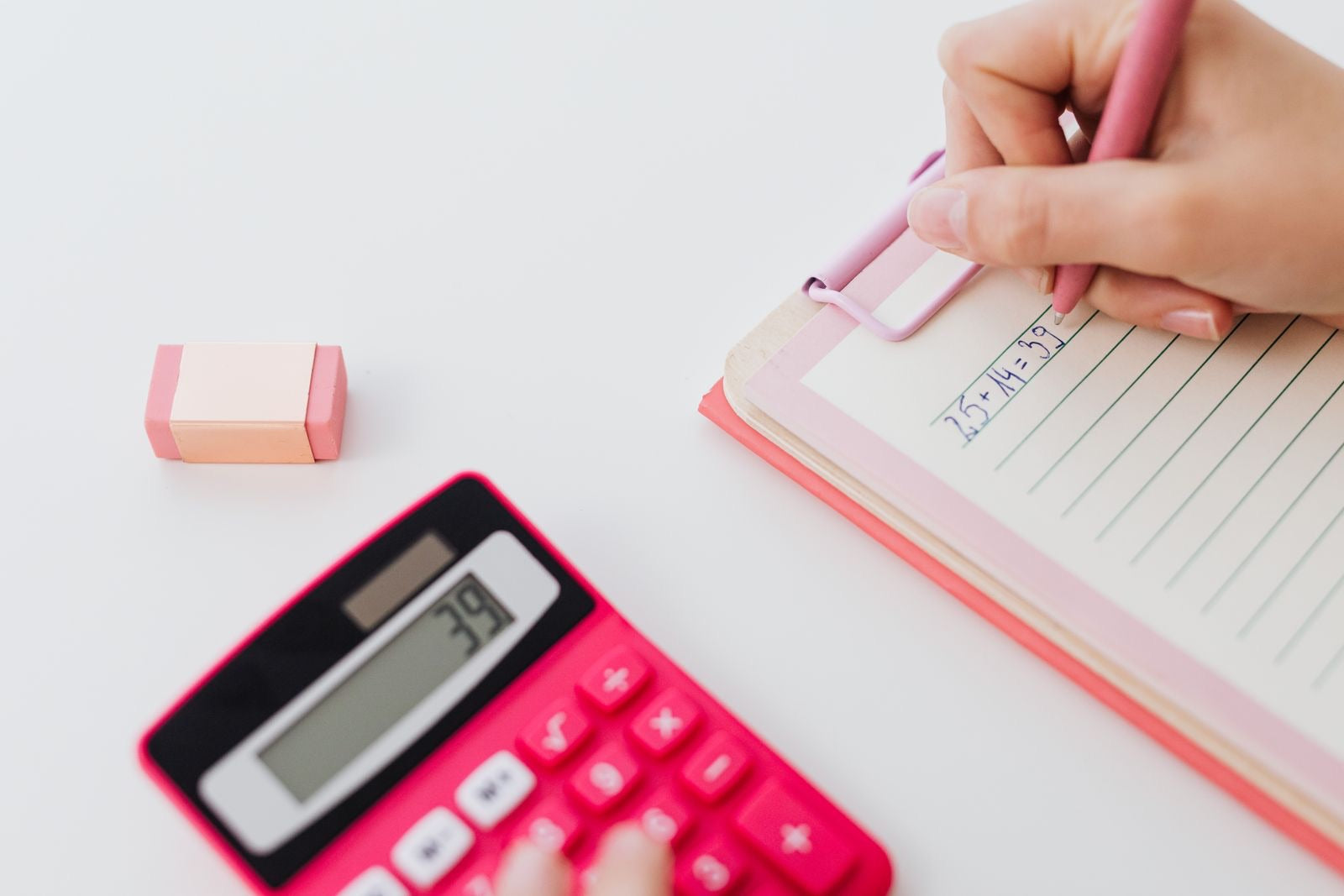 Hands using a calculator and writing equations, representing the PMP exam formulas.