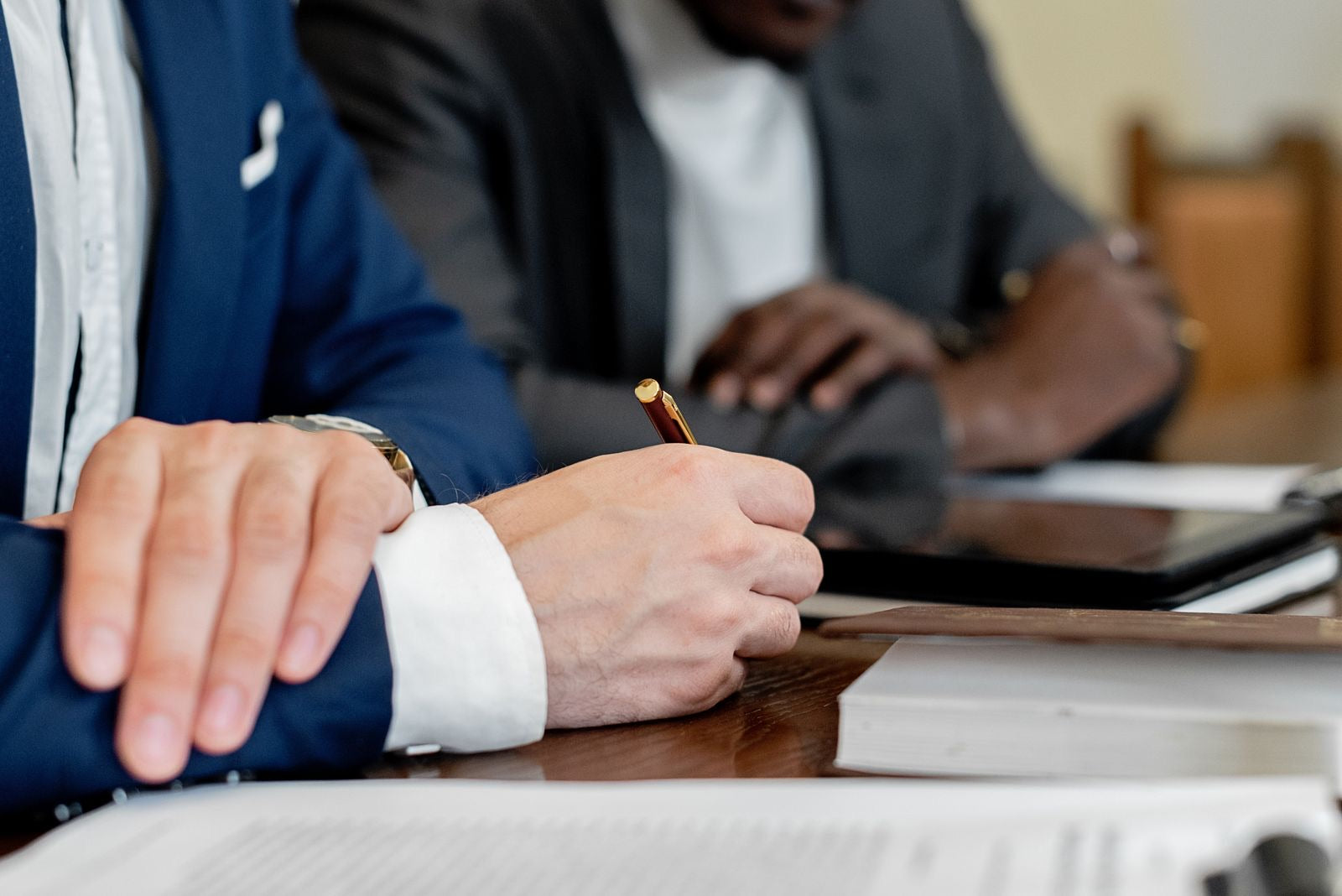 Businessmen at a table reviewing a printed project scope statement before formal approval.
