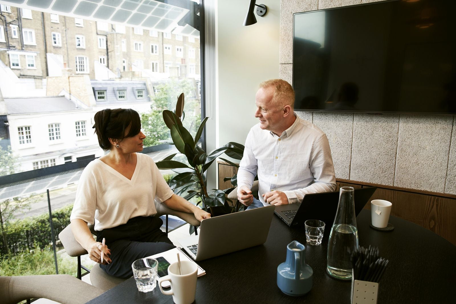 A project manager and a team member discussing what each work package involves, representing defining WBS dictionary entries.