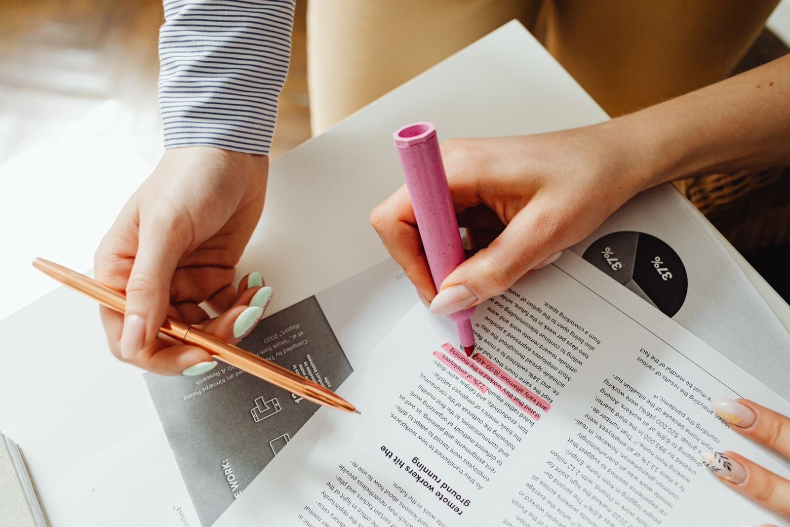Hands highlighting notes on a document, representing studying the CAPM Exam Content Outline.
