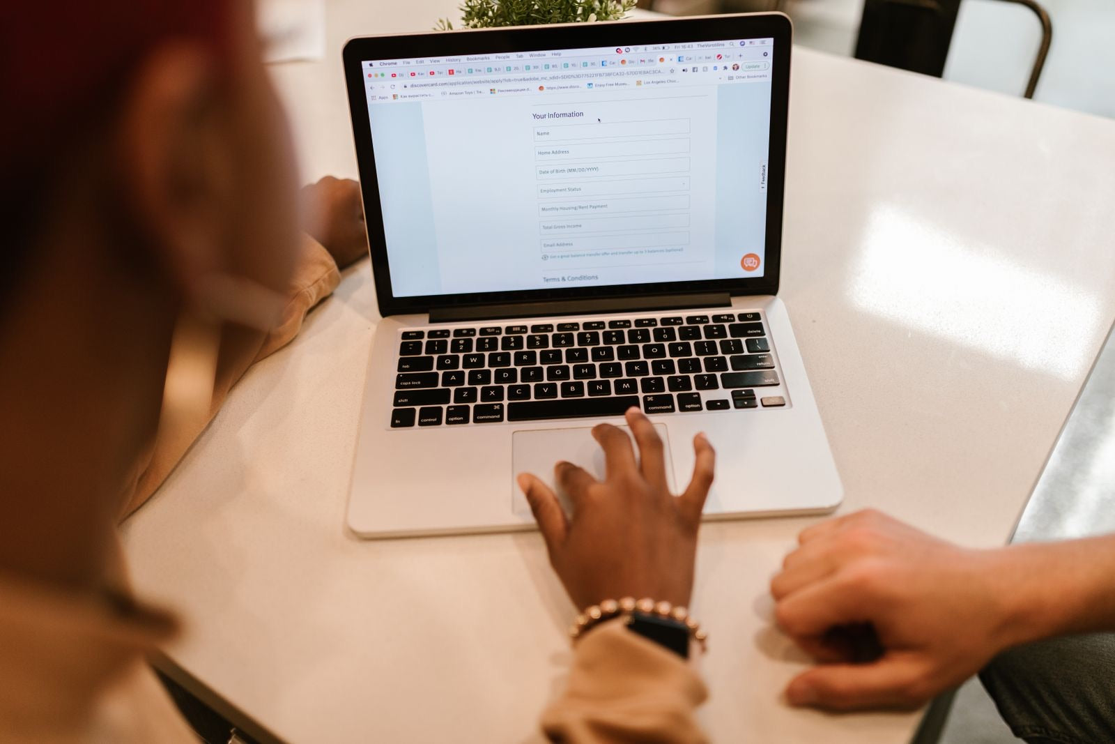 A person completing an online application on a laptop, representing the PMP application process.