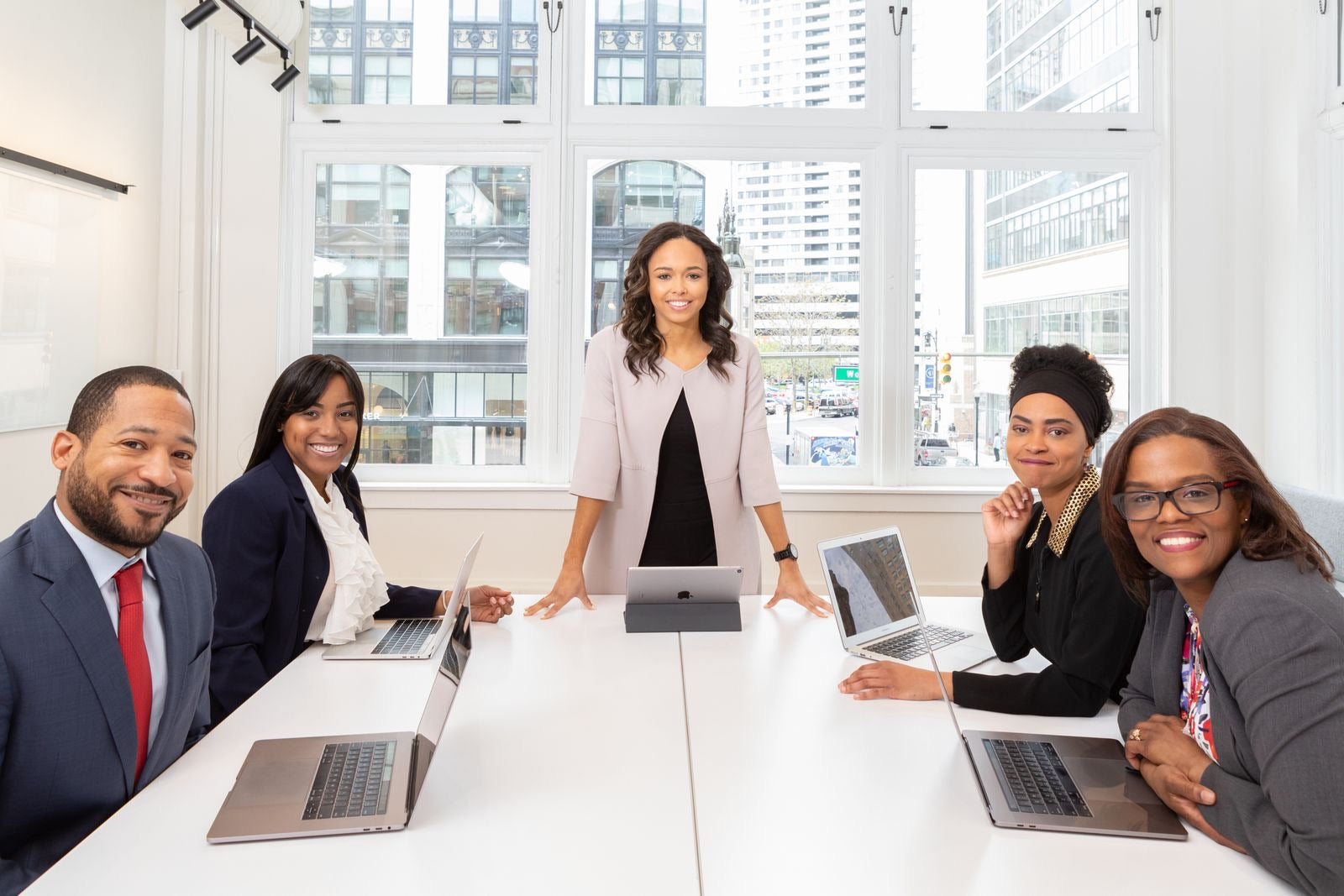 A project manager leading a team meeting in a boardroom, representing PMP certification.